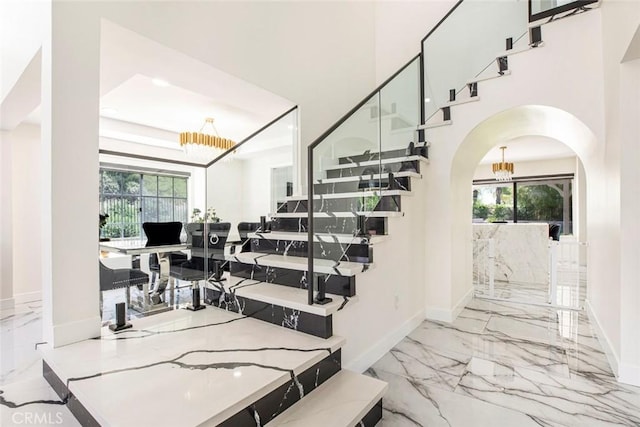 20128 Cavern Ct, Saugus, CA 91390 - stairway with marble tiled flooring, a chandelier, arched walkways, and baseboards