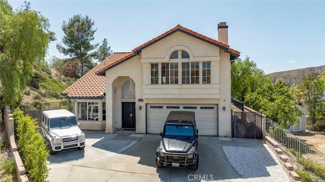 20128 Cavern Ct, Saugus, CA 91390 - mediterranean / spanish house featuring concrete driveway, stucco siding, a chimney, a garage, and a tiled roof