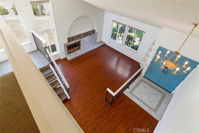 3016 Daphney Ct, Simi Valley, CA 93063 - unfurnished living room featuring wood finished floors, a textured ceiling, a fireplace, a chandelier, and stairs