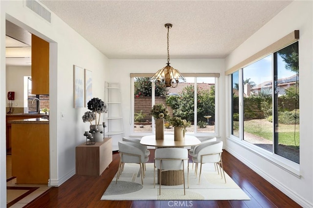 3016 Daphney Ct, Simi Valley, CA 93063 - dining area featuring dark wood-style flooring, a textured ceiling, and a chandelier