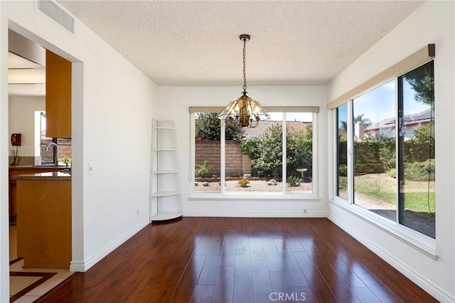 3016 Daphney Ct, Simi Valley, CA 93063 - unfurnished dining area with a chandelier, a textured ceiling, and dark wood-style flooring