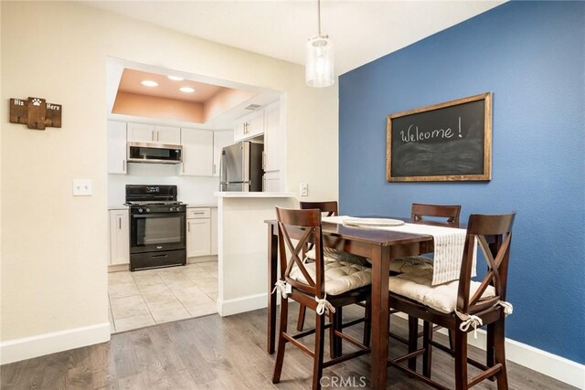 4201 W 5th St Unit 218, Santa Ana, CA 92703 - dining area with baseboards, light wood-style floors, a raised ceiling, and recessed lighting