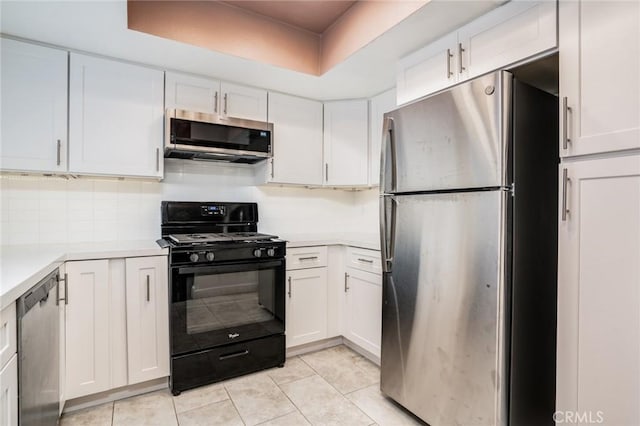 4201 W 5th St Unit 218, Santa Ana, CA 92703 - kitchen featuring stainless steel appliances, light countertops, light tile patterned flooring, white cabinetry, and a raised ceiling