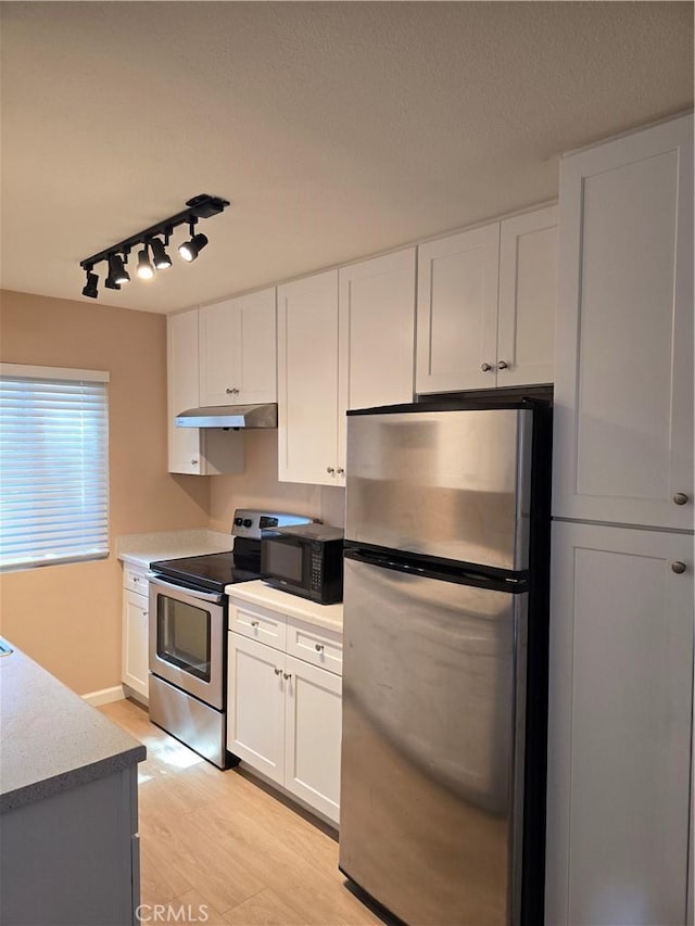 400 N Acacia Ave Unit D16, Fullerton, CA 92831 - kitchen with appliances with stainless steel finishes, under cabinet range hood, rail lighting, white cabinetry, and light wood-style flooring