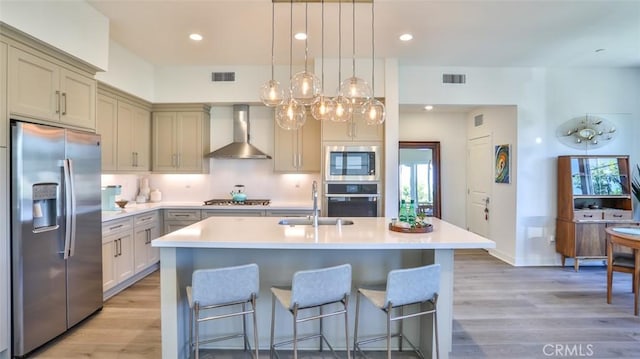 1207 Doheny Way, Dana Point, CA 92629 - kitchen with appliances with stainless steel finishes, wall chimney range hood, light wood-type flooring, light countertops, and recessed lighting