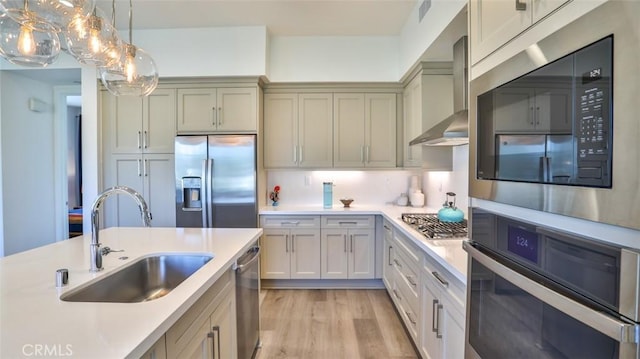 1207 Doheny Way, Dana Point, CA 92629 - kitchen with stainless steel appliances, wall chimney exhaust hood, light countertops, light wood-style flooring, and decorative light fixtures