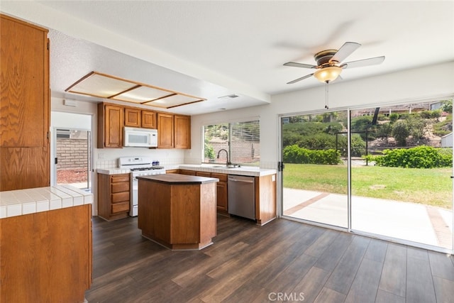 16783 Lake Knl, Riverside, CA 92503 - kitchen with white appliances, a center island, ceiling fan, brown cabinetry, and a sink