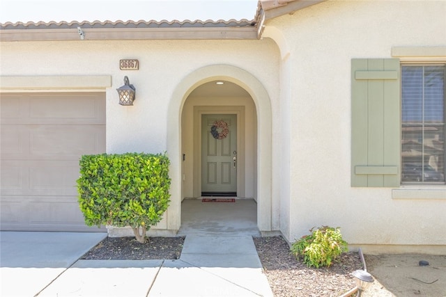 36867 Gallery Ln, Beaumont, CA 92223 - property entrance with stucco siding, a tile roof, and a garage