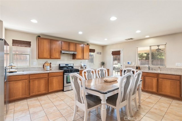 36867 Gallery Ln, Beaumont, CA 92223 - kitchen featuring stainless steel appliances, under cabinet range hood, brown cabinets, light tile patterned floors, and recessed lighting