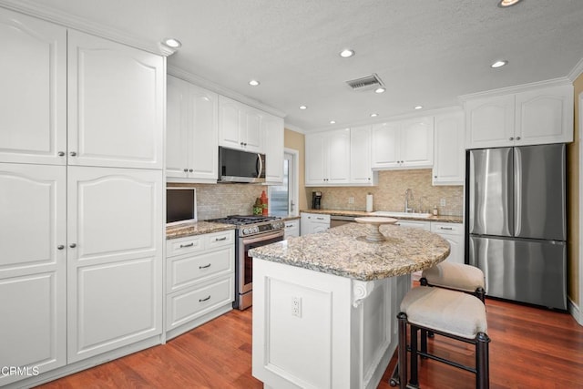 829 E Ada Ave, Glendora, CA 91741 - kitchen featuring stainless steel appliances, dark wood-type flooring, light stone counters, a kitchen island, and recessed lighting