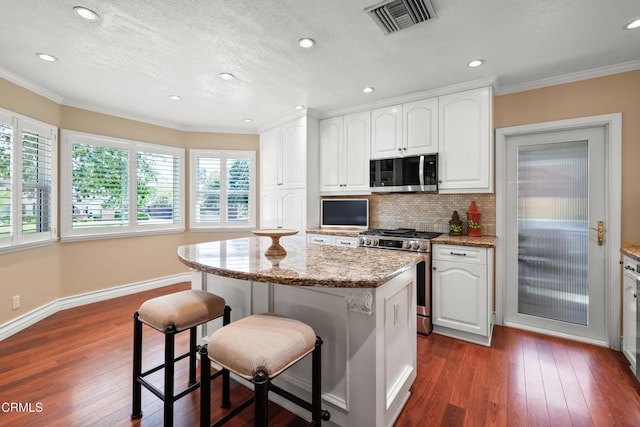 829 E Ada Ave, Glendora, CA 91741 - kitchen with stainless steel range with gas cooktop, crown molding, light stone countertops, a breakfast bar area, and decorative backsplash