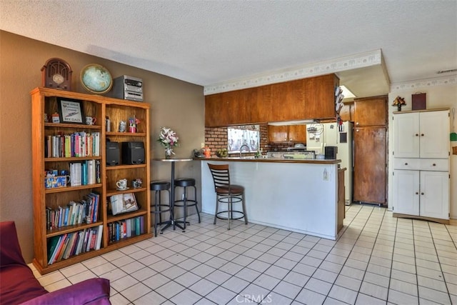 3012 Homer Cir, Jurupa Valley, CA 91752 - kitchen with a textured ceiling, a peninsula, light tile patterned floors, dark countertops, and a breakfast bar