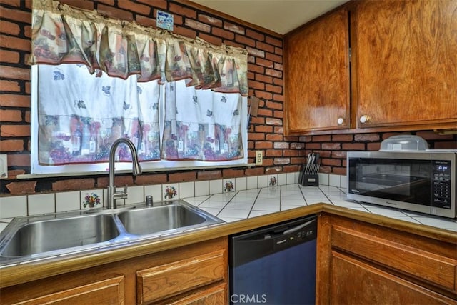 3012 Homer Cir, Jurupa Valley, CA 91752 - kitchen with stainless steel microwave, dishwasher, tile countertops, brown cabinetry, and brick wall