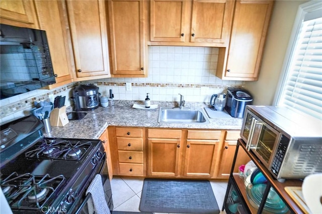 911 Genoa St, Monrovia, CA 91016 - kitchen with black appliances, a sink, tasteful backsplash, light tile patterned floors, and light stone countertops