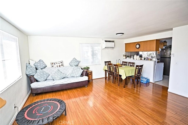 911 Genoa St, Monrovia, CA 91016 - living room featuring a wall mounted AC, light wood-style floors, and baseboards