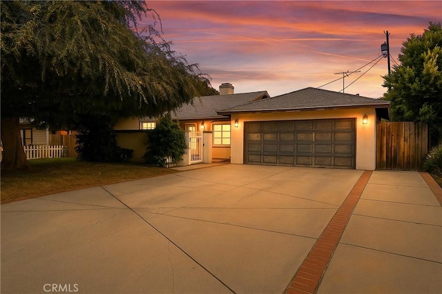 4622 Burnet Ave, Sherman Oaks, CA 91403 - view of front of house with stucco siding, driveway, an attached garage, and a chimney