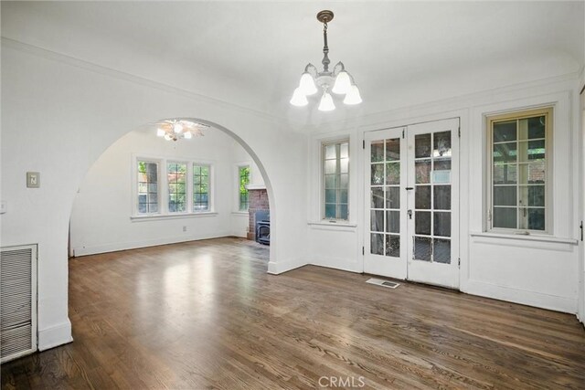 915 Poplar St, Chico, CA 95928 - unfurnished dining area with a chandelier, arched walkways, wood finished floors, french doors, and crown molding