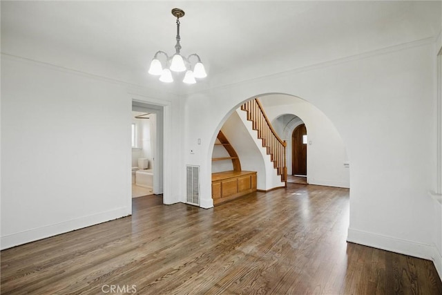 915 Poplar St, Chico, CA 95928 - unfurnished room with a chandelier, wood finished floors, baseboards, and arched walkways