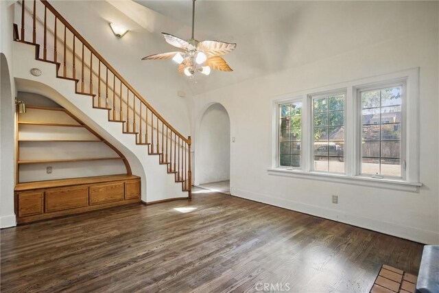 915 Poplar St, Chico, CA 95928 - unfurnished living room with arched walkways, ceiling fan, dark wood-type flooring, stairs, and high vaulted ceiling