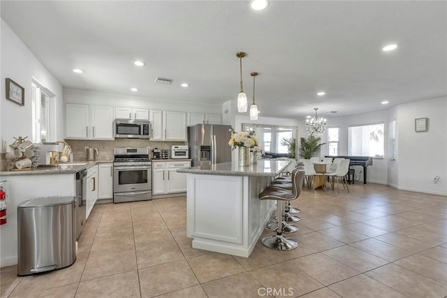 2230 N Volturno Rd, Palm Springs, CA 92262 - kitchen featuring appliances with stainless steel finishes, light tile patterned floors, white cabinetry, a kitchen island, and recessed lighting