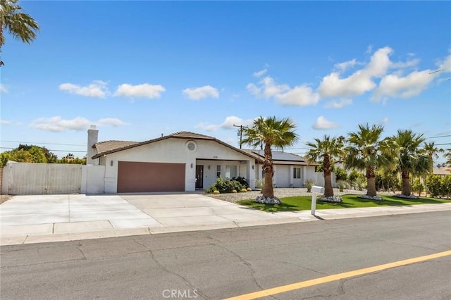 2230 N Volturno Rd, Palm Springs, CA 92262 - single story home featuring stucco siding, an attached garage, solar panels, driveway, and a chimney