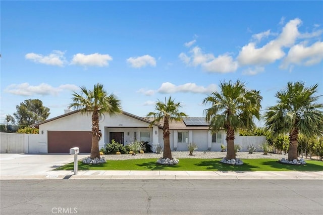 2230 N Volturno Rd, Palm Springs, CA 92262 - single story home with roof mounted solar panels, an attached garage, concrete driveway, and stucco siding