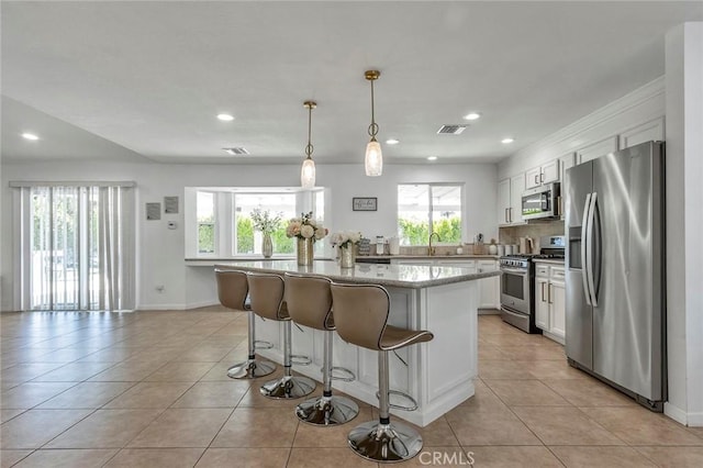 2230 N Volturno Rd, Palm Springs, CA 92262 - kitchen featuring appliances with stainless steel finishes, light tile patterned flooring, a breakfast bar, a sink, and recessed lighting