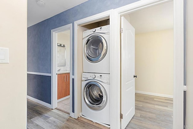 575 7th St # 203, Imperial Beach, CA 91932 - laundry area with stacked washing machine and dryer, wood finished floors, and baseboards