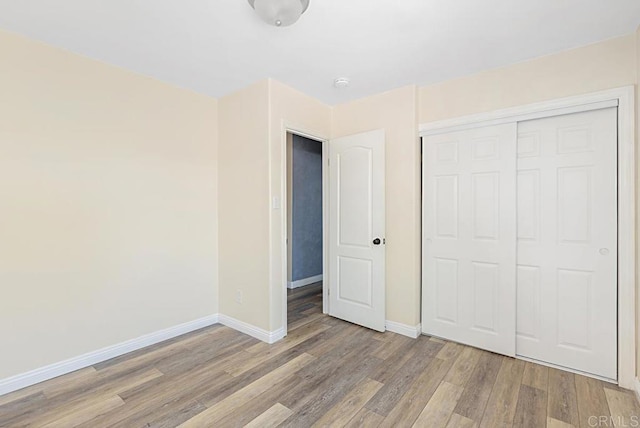 575 7th St # 203, Imperial Beach, CA 91932 - unfurnished bedroom with wood finished floors, baseboards, and a closet