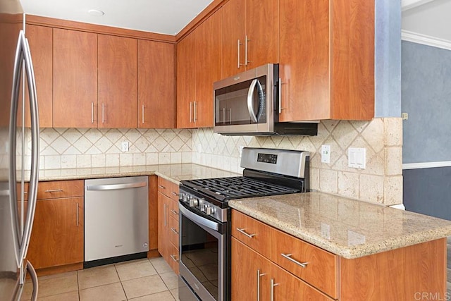 575 7th St # 203, Imperial Beach, CA 91932 - kitchen with appliances with stainless steel finishes, light tile patterned floors, tasteful backsplash, light stone counters, and brown cabinetry
