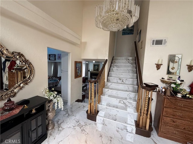 8730 Twin Trails Dr, San Diego, CA 92129 - stairway with a chandelier, marble finish flooring, and a high ceiling