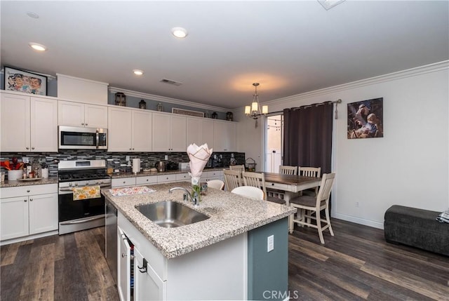 2038 Mesquite Ln, Colton, CA 92324 - kitchen featuring appliances with stainless steel finishes, a sink, crown molding, dark wood finished floors, and decorative backsplash