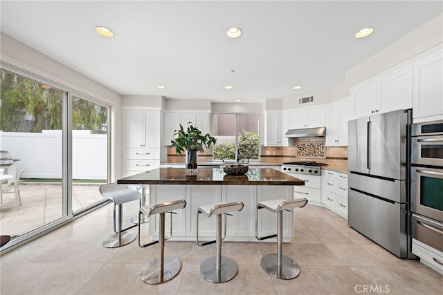 38 Via Sonrisa, San Clemente, CA 92673 - kitchen featuring stainless steel appliances, tasteful backsplash, a kitchen breakfast bar, a kitchen island, and white cabinetry