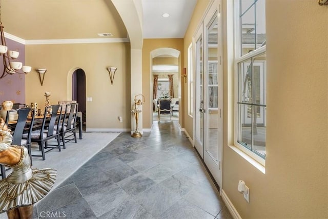 889 Highridge St, Riverside, CA 92506 - hall with arched walkways, ornamental molding, baseboards, stone finish flooring, and a chandelier