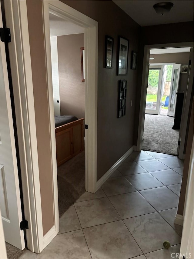 10141 Orange St, Rancho Cucamonga, CA 91737 - hallway featuring light carpet, light tile patterned flooring, and baseboards