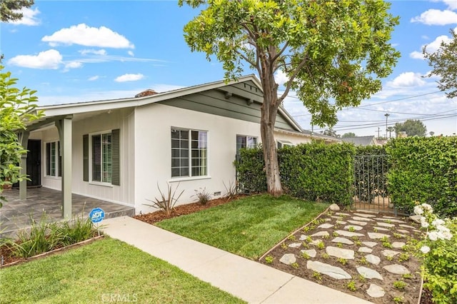 16801 Nordhoff St, Northridge, CA 91343 - view of property exterior featuring a lawn, stucco siding, a patio area, and a gate