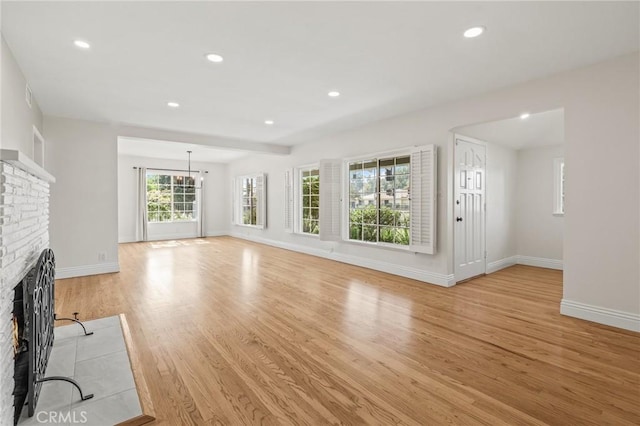 16801 Nordhoff St, Northridge, CA 91343 - unfurnished living room with a brick fireplace, light wood finished floors, recessed lighting, and a chandelier