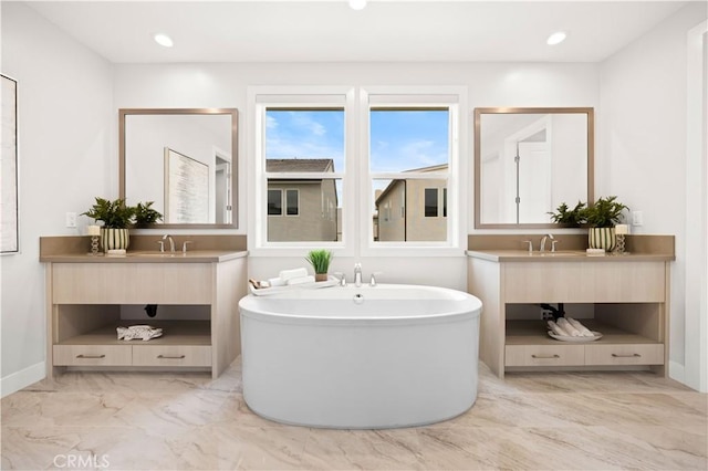 271 Huckleberry, Lake Forest, CA 92630 - bathroom with marble look tiles, a freestanding tub, two vanities, baseboards, and recessed lighting