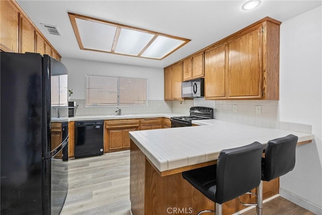 356 Myrl Pl, Hemet, CA 92545 - kitchen featuring black appliances, a peninsula, light wood finished floors, light countertops, and recessed lighting