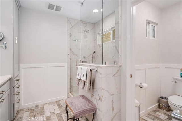 5215 Columbia Way, Lancaster, CA 93536 - full bathroom featuring a decorative wall, a marble finish shower, toilet, and wainscoting