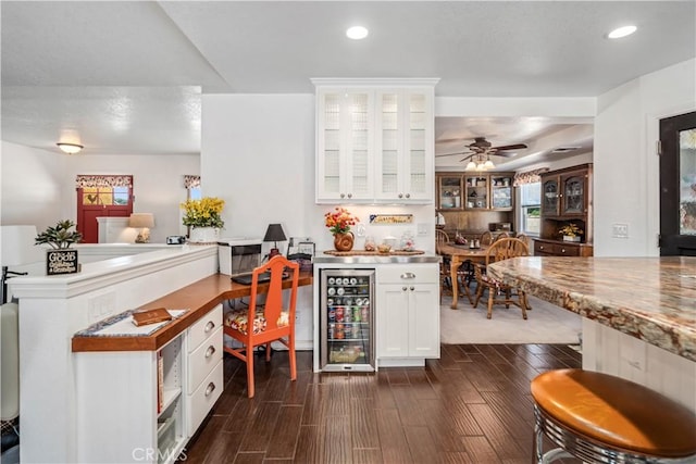 5215 Columbia Way, Lancaster, CA 93536 - kitchen with wine cooler, dark wood-style flooring, recessed lighting, white cabinetry, and glass insert cabinets
