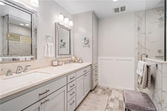 5215 Columbia Way, Lancaster, CA 93536 - full bathroom with double vanity, a marble finish shower, wainscoting, recessed lighting, and a decorative wall