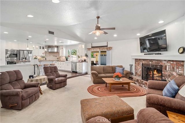5215 Columbia Way, Lancaster, CA 93536 - living area featuring ceiling fan, a brick fireplace, vaulted ceiling, light carpet, and recessed lighting