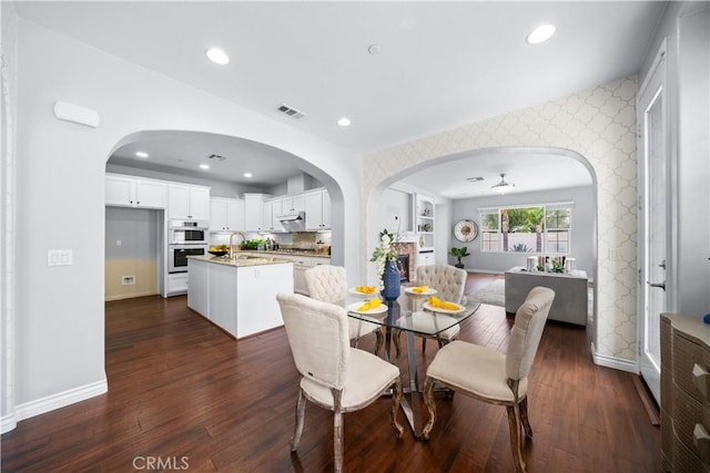 46239 Lone Pine Dr, Temecula, CA 92592 - dining area with baseboards, dark wood finished floors, recessed lighting, arched walkways, and wallpapered walls