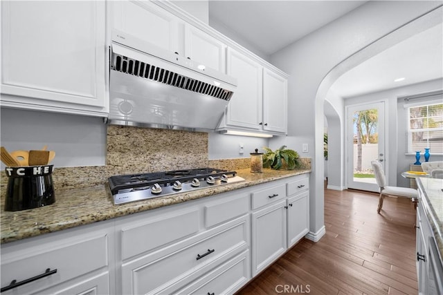 46239 Lone Pine Dr, Temecula, CA 92592 - kitchen with stainless steel gas cooktop, extractor fan, arched walkways, white cabinetry, and decorative backsplash