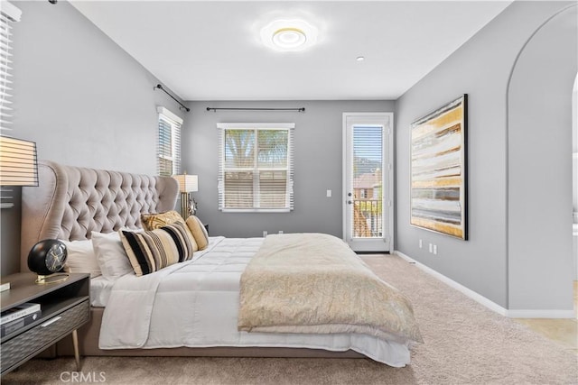 46239 Lone Pine Dr, Temecula, CA 92592 - carpeted bedroom featuring access to exterior, multiple windows, arched walkways, and baseboards