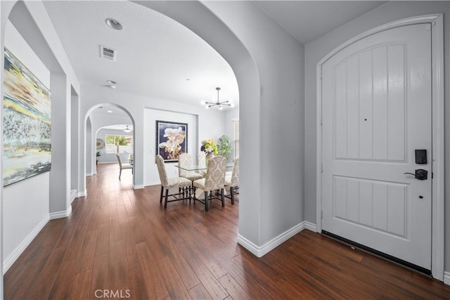 46239 Lone Pine Dr, Temecula, CA 92592 - foyer entrance with arched walkways, a chandelier, dark wood-style flooring, and baseboards