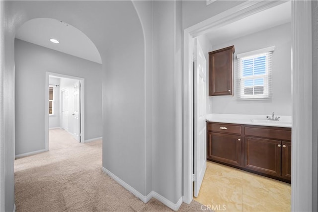 46239 Lone Pine Dr, Temecula, CA 92592 - hall with a sink, arched walkways, baseboards, and light colored carpet