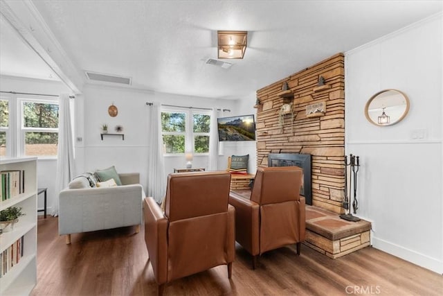 1698 Thrush Rd, Wrightwood, CA 92397 - living area with wood finished floors, a stone fireplace, ornamental molding, and baseboards