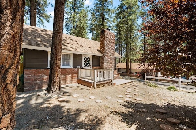 1698 Thrush Rd, Wrightwood, CA 92397 - rear view of property featuring a chimney, brick siding, and a shingled roof